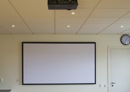 Ljudabsorbent på vägg som fungerar som projektionsduk