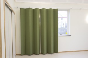 Ljuddämpande gardiner i grönt framför fönster