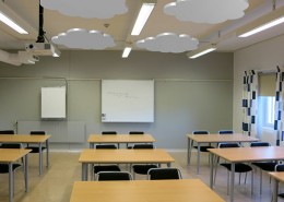 Ljudabsorbent formade som moln monterade i taket i ett klassrum